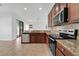 Open kitchen featuring stainless steel appliances, granite countertops, and tile flooring, perfect for entertaining at 7108 Harvest Glen Ln, Riverview, FL 33578