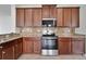 Well-equipped kitchen with granite countertops, stainless steel appliances, and wooden cabinetry at 7108 Harvest Glen Ln, Riverview, FL 33578