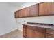 Functional laundry room with rich wood cabinets, countertop space, and tile flooring at 7108 Harvest Glen Ln, Riverview, FL 33578
