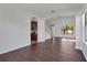 Open-concept living room with wood floors, arched doorways, and a view of the kitchen at 7108 Harvest Glen Ln, Riverview, FL 33578