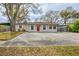 Charming single-story home featuring a red front door, light colored exterior paint, and a spacious front yard at 8528 Gold Ridge Cir, Tampa, FL 33619
