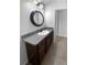 This bathroom includes a sink with granite counters and modern dark brown cabinets at 36017 Stable Wilk Ave, Zephyrhills, FL 33541