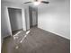 This bedroom includes carpet, neutral walls, a ceiling fan, and a closet with shelving at 36017 Stable Wilk Ave, Zephyrhills, FL 33541