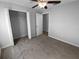 This bedroom includes carpet, neutral walls, a ceiling fan, and a closet with shelving at 36017 Stable Wilk Ave, Zephyrhills, FL 33541