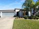 Charming single-story home with a well-manicured lawn, landscaped garden, and a two-car garage at 36017 Stable Wilk Ave, Zephyrhills, FL 33541