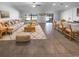 Bright, open-plan living room featuring neutral colors, tile floors, modern furnishings, and outdoor views at 36017 Stable Wilk Ave, Zephyrhills, FL 33541