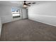 Neutral tone main bedroom, window overlooking the backyard, and carpeted floors at 36017 Stable Wilk Ave, Zephyrhills, FL 33541