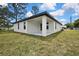 Exterior shot of a modern home with a covered porch, large windows, and manicured green lawn at 10383 Lear St, Spring Hill, FL 34608