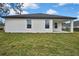 Exterior shot of modern home with a covered porch, large windows, and green, well-maintained lawn at 10383 Lear St, Spring Hill, FL 34608