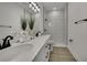 Modern bathroom with double sinks, white countertops, black fixtures, and walk-in shower at 10383 Lear St, Spring Hill, FL 34608