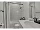 Bathroom featuring white subway tile, a shower-tub combo, and a bright white vanity with black hardware at 10383 Lear St, Spring Hill, FL 34608