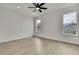 Bright bedroom with ceiling fan features neutral walls, light wood floors, and three windows at 10383 Lear St, Spring Hill, FL 34608