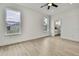 Bright bedroom with ceiling fan features neutral walls, light wood floors, and view to bathroom at 10383 Lear St, Spring Hill, FL 34608