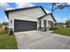 A modern home with gray garage door, white accents, and a well-manicured front lawn at 10383 Lear St, Spring Hill, FL 34608