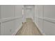 Bright hallway with wood-look flooring, crisp white trim, and modern wainscoting detail at 10383 Lear St, Spring Hill, FL 34608