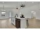 Contemporary kitchen with a white island, stainless steel sink, and sleek black appliances at 10383 Lear St, Spring Hill, FL 34608