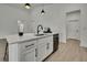 Bright kitchen island featuring a black faucet, white countertop, black hardware, and stainless-steel sink at 10383 Lear St, Spring Hill, FL 34608
