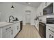 Modern kitchen with white cabinetry, island with seating, and stainless steel appliances at 10383 Lear St, Spring Hill, FL 34608