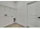 Small laundry room with laminate floors and white walls, with a white door leading to another space at 10383 Lear St, Spring Hill, FL 34608