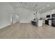 Open concept living space featuring modern kitchen, island with seating, and light wood floors at 10383 Lear St, Spring Hill, FL 34608