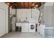 Functional basement laundry area with washer, dryer, utility sink, and water heater, ready for any mess at 1154 64Th S Ave, St Petersburg, FL 33705