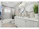 Modern bathroom features a double vanity with stylish mirrors, a shower/tub combo, and fresh plants at 1154 64Th S Ave, St Petersburg, FL 33705