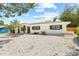Charming single-story home featuring a white exterior, dark trim, and well-maintained landscaping at 1154 64Th S Ave, St Petersburg, FL 33705
