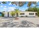 Charming single-story home with white exterior, dark trim, palm trees, and modern landscaping at 1154 64Th S Ave, St Petersburg, FL 33705