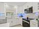 Bright kitchen featuring marble countertops, sleek appliances, and modern white cabinetry with gold hardware at 1154 64Th S Ave, St Petersburg, FL 33705
