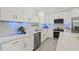Bright kitchen featuring marble countertops, sleek appliances, and modern white cabinetry with gold hardware at 1154 64Th S Ave, St Petersburg, FL 33705