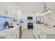 Bright kitchen featuring marble countertops, sleek appliances, an island and modern white cabinetry with gold hardware at 1154 64Th S Ave, St Petersburg, FL 33705