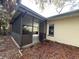Exterior view of a screened-in porch with an open door and view of the backyard at 1501 Delaware Ne Ave, St Petersburg, FL 33703