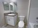 Well-lit bathroom features a granite vanity top, a sink, toilet, and a shower-tub combo at 1526 Cassius St, Lutz, FL 33549
