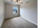 This bedroom offers natural light, plush carpeting, a ceiling fan, and neutral paint for easy personalization at 1526 Cassius St, Lutz, FL 33549