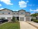 Townhouse exterior features a well-manicured lawn, concrete driveway, attached garages, and beautiful blue shutters at 1526 Cassius St, Lutz, FL 33549