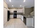 Well-lit kitchen featuring white cabinets, granite countertops, and stainless steel appliances at 1526 Cassius St, Lutz, FL 33549
