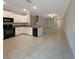 Open-concept kitchen featuring white cabinets, black appliances, and views of the living area at 1526 Cassius St, Lutz, FL 33549