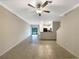Spacious living room with tile flooring, ceiling fan, leading to an open-concept kitchen and backyard access at 1526 Cassius St, Lutz, FL 33549