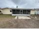 Backyard view of house with screened in porch, patio and lawn at 1998 Cove Dr, Largo, FL 33774