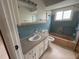 Bathroom with blue tile, a vanity, and a bathtub-shower, ready for updates and personalization at 1998 Cove Dr, Largo, FL 33774