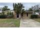 Charming single-story home with a stucco exterior, mature palm trees, and a spacious driveway at 4200 Huntington Ne St, St Petersburg, FL 33703