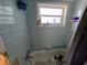 Bathroom ready for renovation featuring blue tile surround and natural light at 4706 Lansing Ne St, St Petersburg, FL 33703