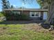Charming brick home featuring a mature tree, tire swing and well-maintained lawn at 4706 Lansing Ne St, St Petersburg, FL 33703