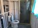 Demolition view of the bathroom reveals a toilet and shower, ready for renovation at 6220 Keller Dr, Port Richey, FL 34668
