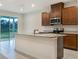 This kitchen has stainless steel appliances, a gray granite island, and wood cabinets at 6310 116Th E Ave, Parrish, FL 34219