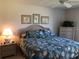 Bedroom with a queen bed featuring seashell bedding, coastal artwork, and wicker furniture at 6211 Timber Lake Dr # B4, Sarasota, FL 34243