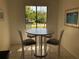 Bright dining area with a round table, four chairs, and natural light streaming through the window at 6211 Timber Lake Dr # B4, Sarasota, FL 34243