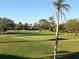 Scenic golf course view with lush green grass, sand traps, trees, and clear blue sky at 6211 Timber Lake Dr # B4, Sarasota, FL 34243