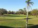 Scenic golf course view with lush green grass, sand traps, and mature trees under a clear blue sky at 6211 Timber Lake Dr # B4, Sarasota, FL 34243