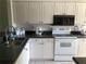 Functional kitchen equipped with white appliances, ample cabinet space, and dark countertops at 6211 Timber Lake Dr # B4, Sarasota, FL 34243